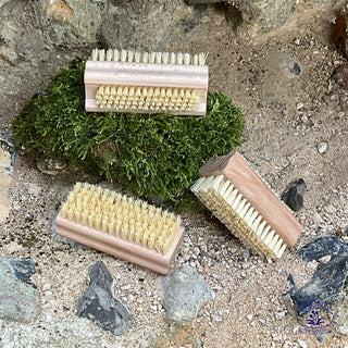 3 stiff natural nail brushes with moss on wall