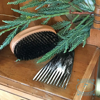 perfect hair oval bristle brush and horn comb on dressing table with folliage